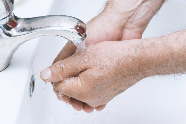old man washes his hands in the bathroom.The best protection against corona virus infection.Corona Virus pandemic protection by cleaning hands frequently. - Foto, Imagem