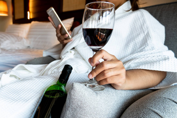The hand of Young woman that hold wine glass And Sit play telephone In a luxurious room. - Foto, immagini