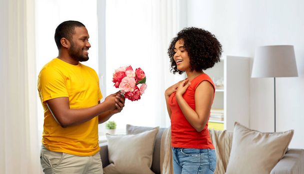 happy african american couple with flowers - Fotoğraf, Görsel