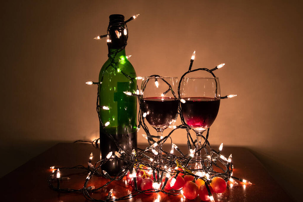 Пляшка вина, келих для вина та блискучий вогонь Готовий вечір у спальні
. - Фото, зображення