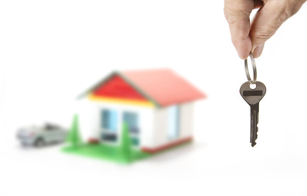 Ключ від будинку в руці на білому
 - Фото, зображення
