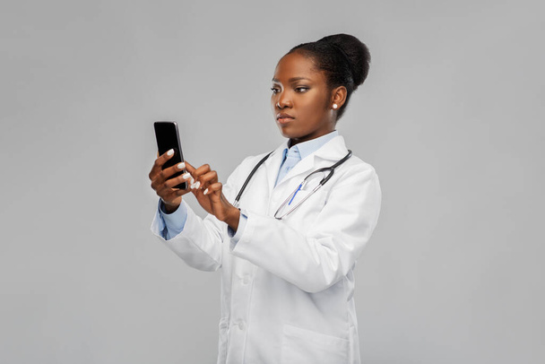 african american female doctor with smartphone - Φωτογραφία, εικόνα