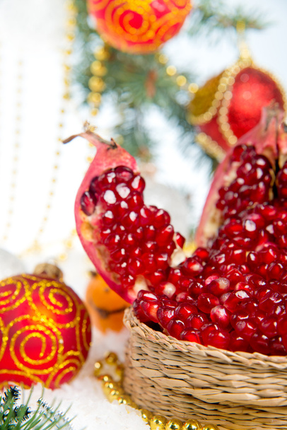 Fresh pomegranate. Christmas decorations for the Christmas tree on a wooden table. - Foto, immagini