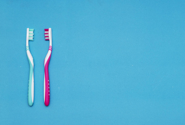 Sininen ja punainen hammasharja sinisellä pohjalla. Hammasharjan vaihtamisen käsite, suuhygienia, suuri ja ystävällinen perhe, hammasharjan valinta
 - Valokuva, kuva