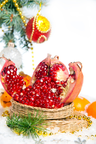 Fresh pomegranate. Christmas decorations for the Christmas tree on a wooden table. - Foto, Bild