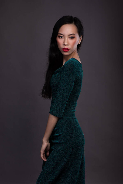 Stüdyoda koyu arkaplanda kırmızı dudaklı Asyalı kadının portresi. - Fotoğraf, Görsel