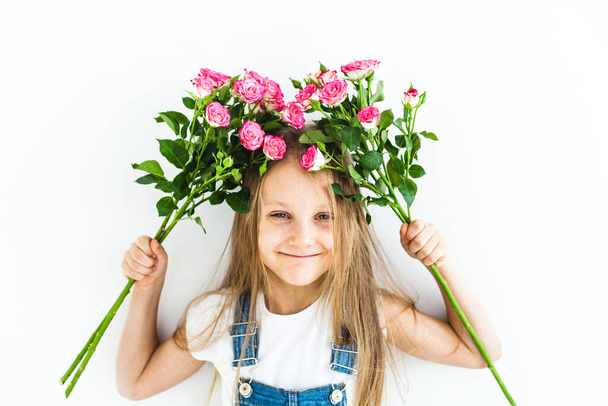 A girl of European appearance with long blond hair, smiling, emotions, joy, friendship, family, holding roses, delicate flowers, flowers for her mother - Photo, image