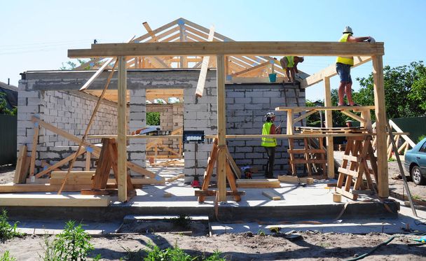 KYIV, UCRANIA - 26 de marzo de 2020: Los techos instalan vigas de madera en el techo. Construyendo el marco de la azotea de vigas de madera
.  - Foto, imagen