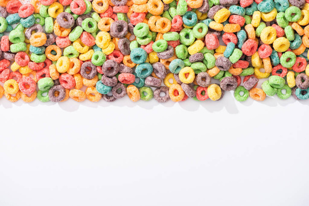 top view of bright multicolored breakfast cereal on white background - Fotó, kép