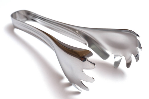 A stainless steel kitchen pliers for spaghetti - Foto, Imagen