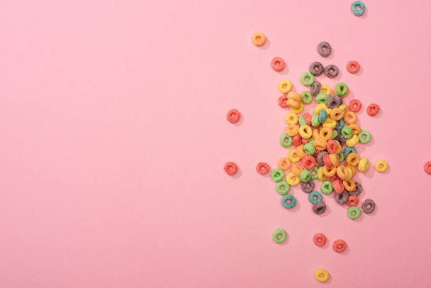 top view of bright multicolored breakfast cereal on pink background - Foto, imagen