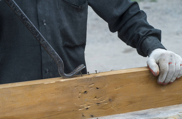 Ein Tischler in schmutziger Kleidung arbeitet auf einer Baustelle - Foto, Bild