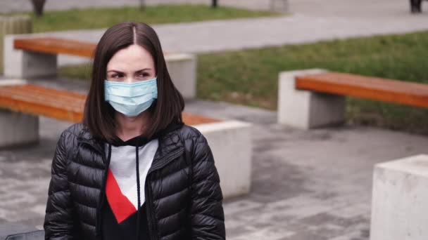Woman in a disposable mask is teaching her child to wear a respirator - Footage, Video