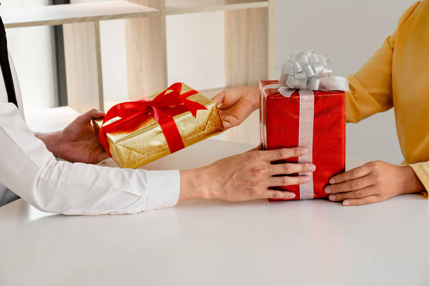Boy and girl Give Christmas and New Year gifts to each other. - 写真・画像