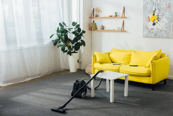 Vacuum cleaner near coffee table in living room - Fotografie, Obrázek