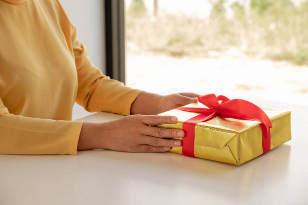 Γυναικεία χέρια κρατώντας κουτί δώρου Χριστούγεννα και το νέο έτος δώρο. - Φωτογραφία, εικόνα