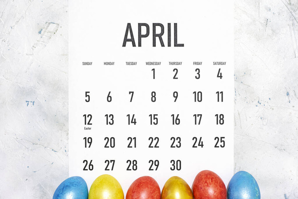 Calendrier mensuel Avril 2020 avec des œufs de Pâques décorés colorés. Vue d'en haut. Vue de dessus. Vacances de Pâques, festives, concepts printaniers
 - Photo, image