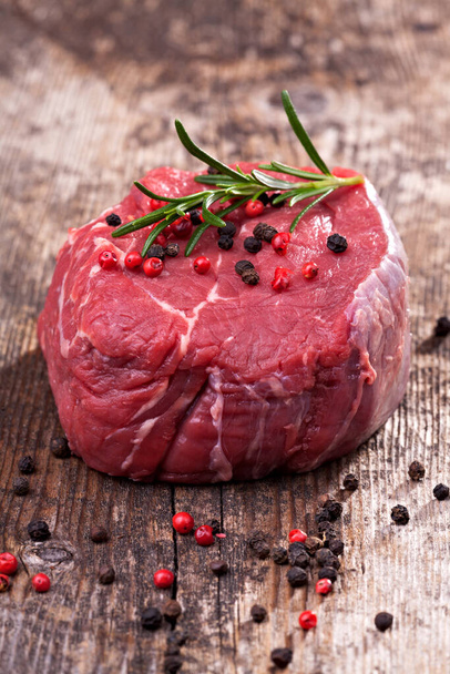 raw steak with pepper on wood - Foto, afbeelding