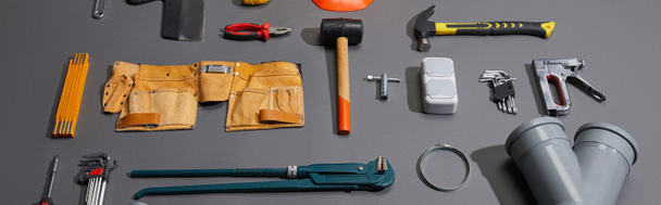 panoramic shot of industrial tools and tool belt on grey background - Photo, Image