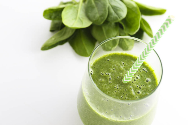 Freshly made green smoothie made of vegetables, fruits, herbs and greens. Glass of blended vegan beverage with ingredients around. Top view, close up, copy space, background. - Photo, Image