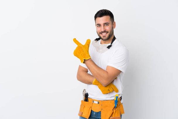 Craftsmen or electrician man over isolated white background pointing finger to the side - Фото, зображення