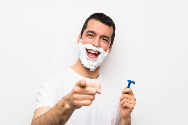 Man shaving his beard over isolated white background points finger at you with a confident expression - Foto, Imagen