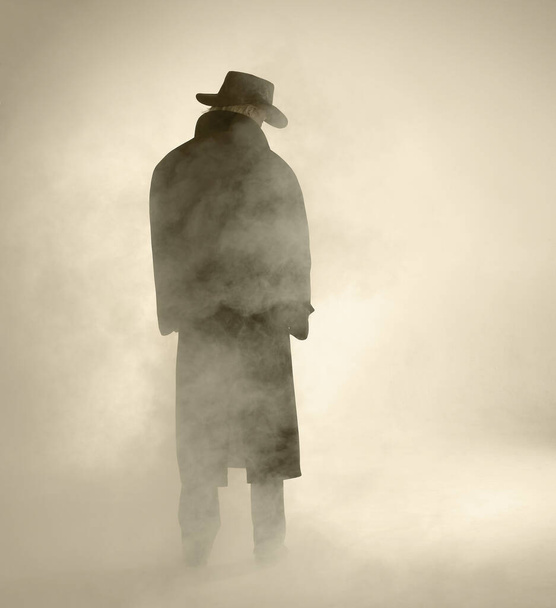woman with dark coat standing in the fog - Valokuva, kuva