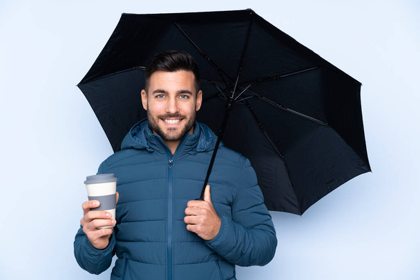 Чоловік тримає парасольку над ізольованим тлом
 - Фото, зображення