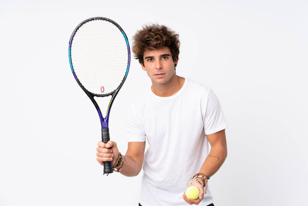 Young caucasian man over isolated white background playing tennis - Fotografie, Obrázek