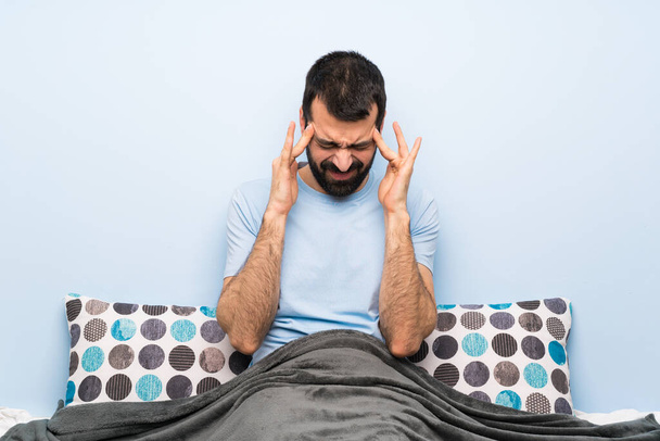Hombre en la cama con dolor de cabeza
 - Foto, Imagen
