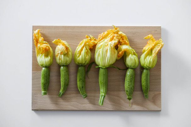 Fresh uncooked green and yellow zucchini flowers. Vegan nutritious food. Clean eating concept. Bacground, copy space, close up, top view. - Фото, изображение