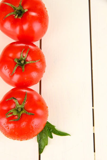 Fresh tomatoes on white wooden background - Фото, изображение