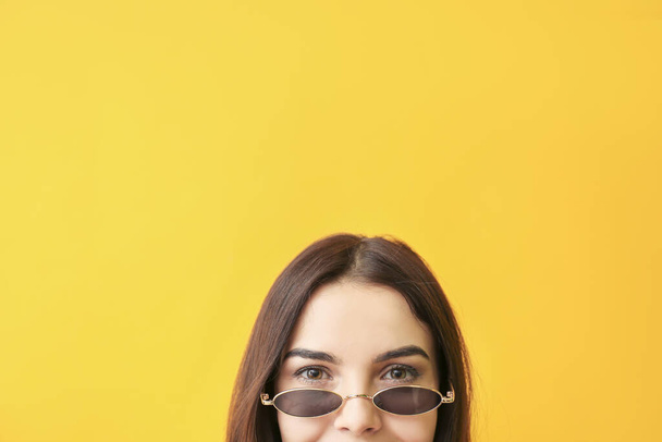 Fiatal nő stílusos napszemüveg a színes háttér - Fotó, kép