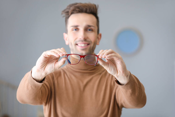 Young man with stylish eyeglasses at home - Фото, зображення