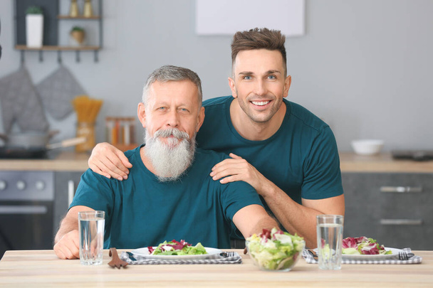 Portrait de l'homme âgé et de son fils adulte dans la cuisine
 - Photo, image