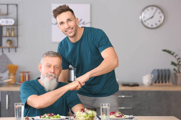 Ritratto di uomo anziano e suo figlio adulto in cucina
 - Foto, immagini