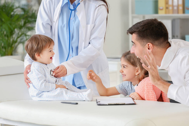 Homem com crianças visitando pediatra na clínica
 - Foto, Imagem