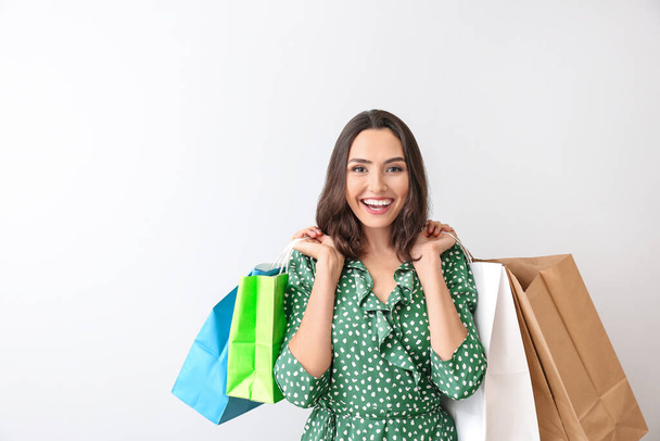 Mulher bonita com sacos de compras no fundo claro
 - Foto, Imagem