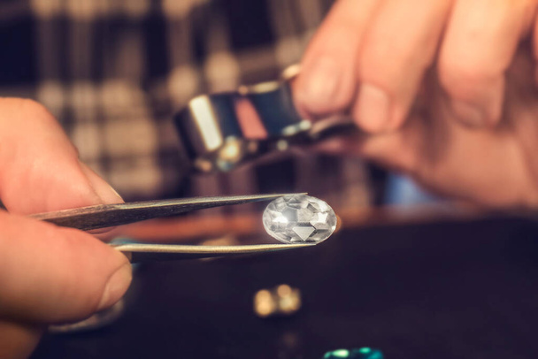 Jeweler examining gemstone in workshop, closeup - Photo, Image