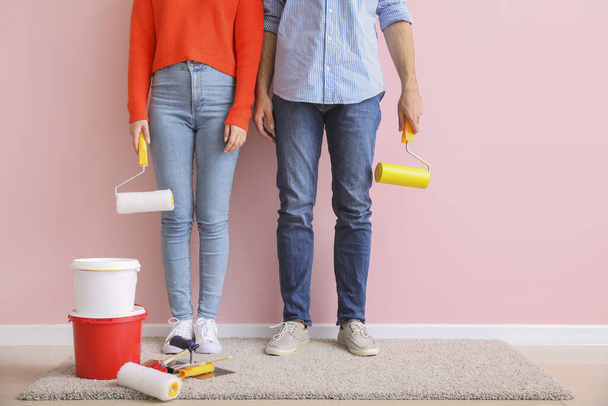 Jeune couple avec des outils près du mur de couleur dans un nouvel appartement
 - Photo, image