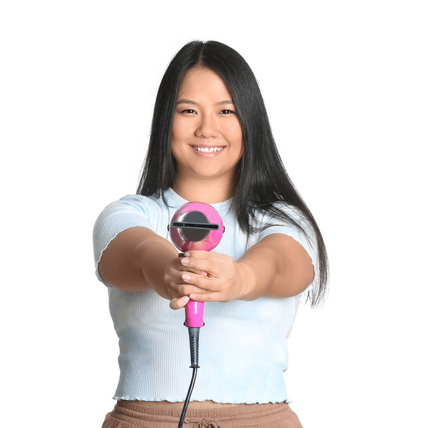 Beautiful Asian woman with hair dryer on white background - Фото, изображение