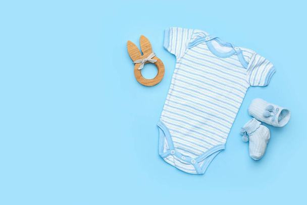 Baby clothes with toy and socks on color background - Photo, Image