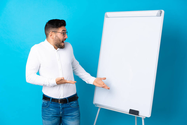 Businessman giving a presentation on white board giving a presentation on white board and with surprise expression - Zdjęcie, obraz