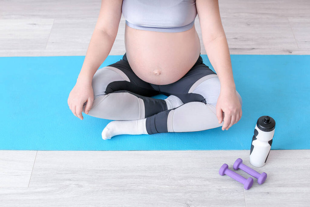 Beautiful pregnant woman doing yoga in gym - Fotó, kép