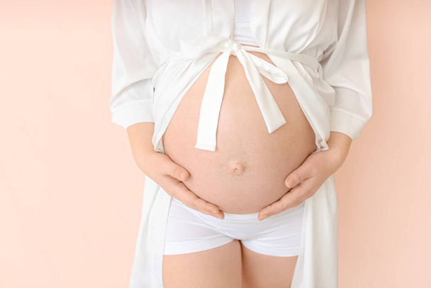 schöne schwangere Frau auf farbigem Hintergrund, Nahaufnahme - Foto, Bild