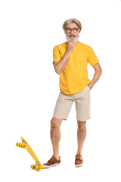 Stylish elderly man with skateboard on white background - Photo, Image