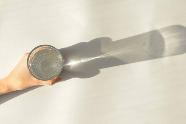 Female hand with glass of water on white background - Foto, afbeelding