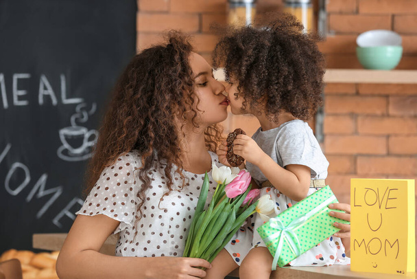 Mujer afroamericana con regalo para el Día de la Madre recibido de su pequeña hija en casa
 - Foto, Imagen