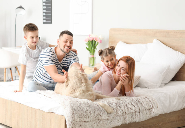 Happy family with dog in bedroom at home - Fotó, kép