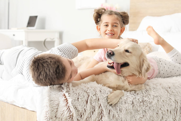 Happy children with dog in bedroom at home - Фото, изображение